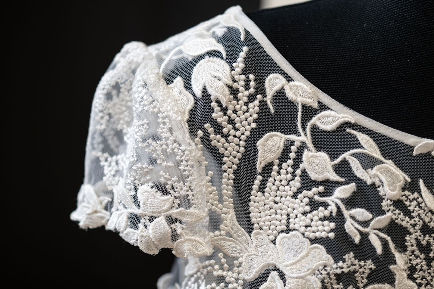 Mancherons, application des motifs cousus main pour les finitions du bas. Tulle brodé Stragier
