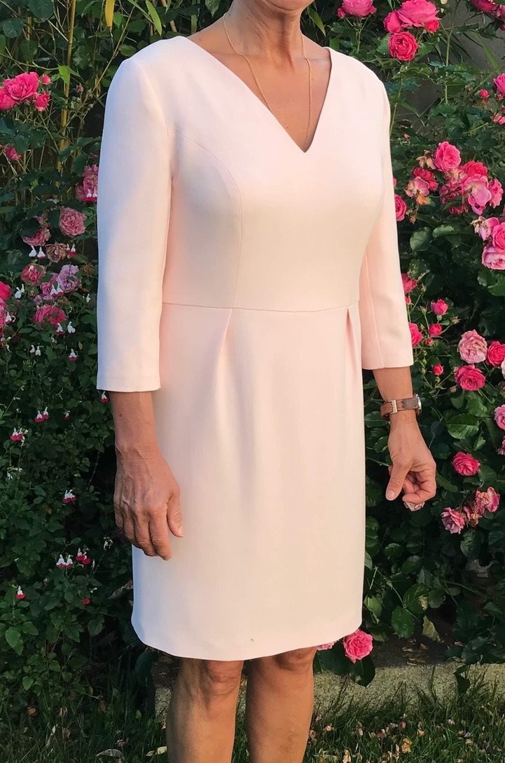 Robe en crêpe de polyester, encolure V, plis plats à la taille.