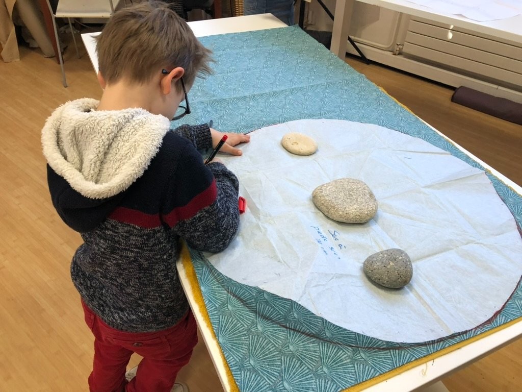 Préparation du sac à pieds secs. Traçage du cercle sur le tissu, avant de le découper. (Augustin 6 ans)